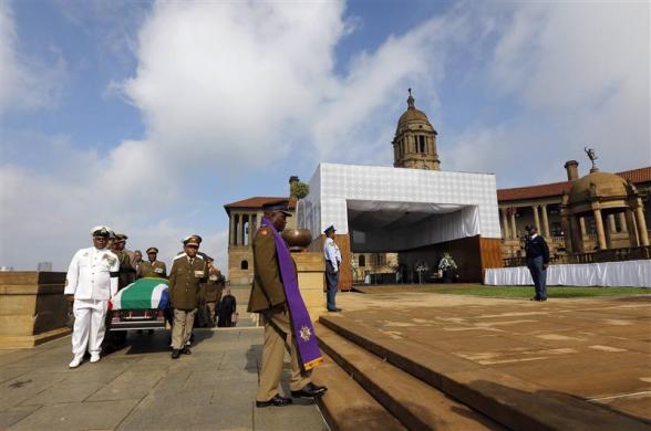 Military personnel carry the remains of the late Nelson Mandela upon arrival at the Union Buildings in Pretoria