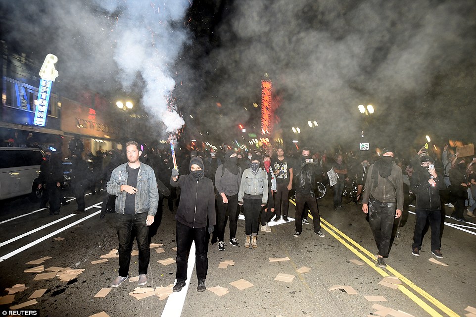 3a38993c00000578-3923346-a_protester_shoots_fireworks_at_police_officers_during_rioting_i-a-20_1478798612413